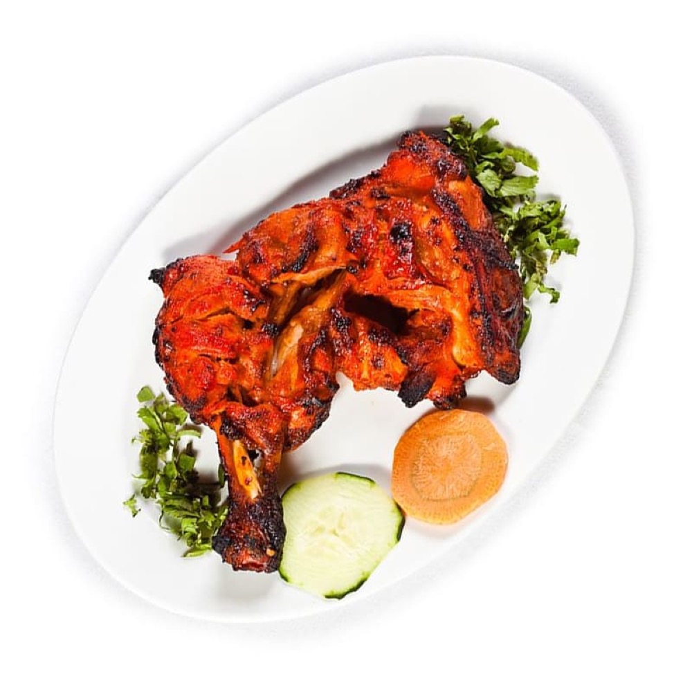 Sufraq Tikka Leg, a marinated chicken leg charcoal-grilled with smoky spice
